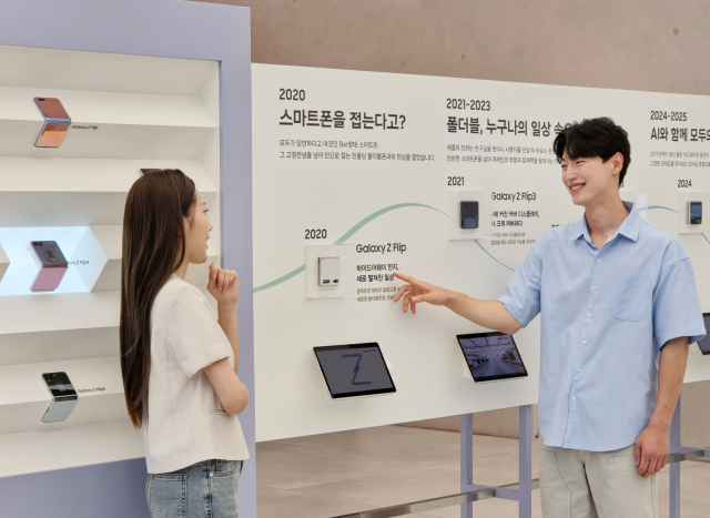 삼성전자 모델이 ‘폴더블 헤리티지’의 ‘갤럭시 폴드·플립 스토리’ 섹션에서 역대 갤럭시 폴더블 라인업을 확인하는 모습