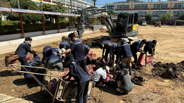 한국교육시설안전원 직원들이 26일 경남 거제 장평초등학교에서 수해 잔해물과 오염물 등을 정리하며 학교 정상화를 위한 복구활동에 힘을 보태고 있다(사진=한국교육시설안전원)