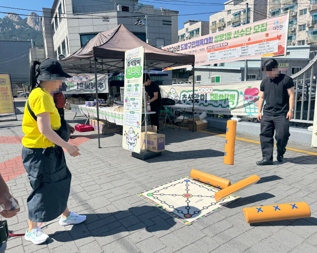 백운시장 추석맞이 페이백 이벤트에서 방문객이 윷놀이에 참여해 상인회가 마련한 경품에 도전하고 있다