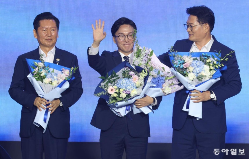  더불어민주당 김민석 신임 대표(가운데)가 17일 대전 유성구 대전컨벤션센터에서 열린 전국당원대회에서 최종 득표율 54.08%로 임기 2년의 새 대표로 선출된 후 웃으며 인사하고 있다. 2위 정청래 의원(왼쪽)은 굳