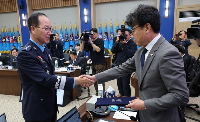 손석락 공군참모총장(왼쪽)이 20일 오후 충남 계룡시 계룡대에서 열린 국회 국방위원회의 공군본부 등에 대한 국정감사에서 진성준 위원장에게 증인선서문을 제출한 뒤 악수하고 있다. [계룡=연합뉴스]