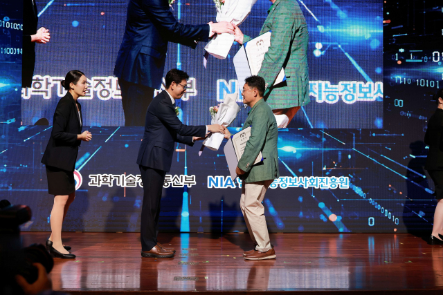 정창래 행복ICT 대표가 ‘제39회 정보문화의 달 기념식’에서 배경훈 부총리 겸 과학기술정보통신부 장관에게 대통령상을 수상한 후 꽃다발을 받고 있다