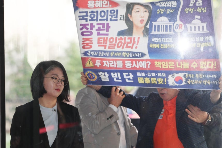 용혜인 성평등가족부 장관 후보자가 11일 오전 서울 서대문구 한국청소년활동진흥원에서 ‘국회의원과 장관 중 택일하라’고 적힌 현수막을 들고 항의하는 시민을 뒤로한 채 인사청문회 준비 사무실로 출근하고 있다. 2026.