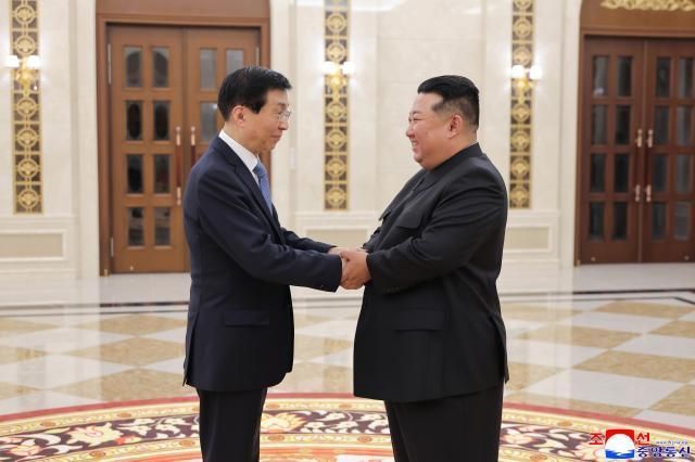 김정은 북한 국무위원장(오른쪽)이 지난 6월 왕후닝 중국 전국정치협상회의 주석과 만나 악수하고 있다.ⓒ신화통신/연합뉴스